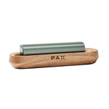 PAX Wood Charging Tray shown with a sleek, modern design, featuring a wooden base and a green object, perfect for charging PAX vaporizers stylishly.