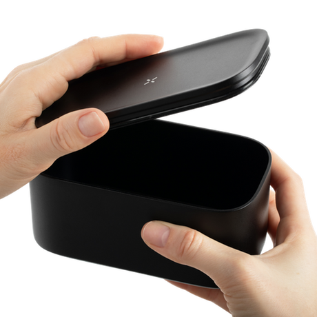 Hand holding a black Stash Jar, designed for smell-proof storage of herbs, featuring a sleek, portable design made from high-quality aluminum.
