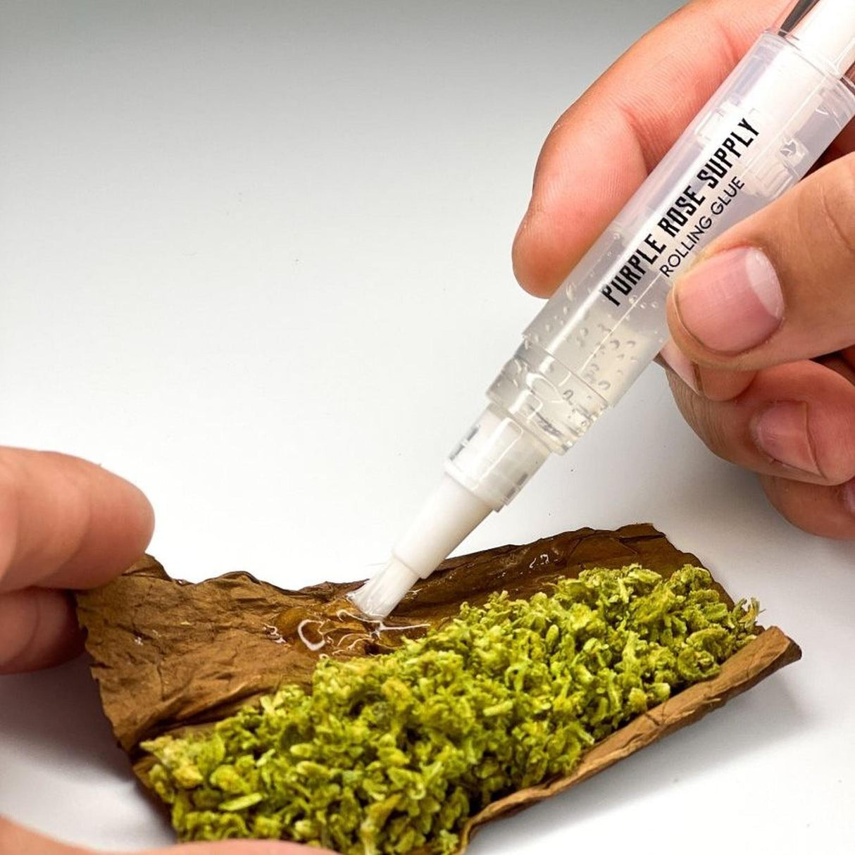 Rolling Glue Box - 4 ml - Carton of 24, featuring a hand holding a pipette and a tube, highlighting its spit-free adhesive and built-in brush for precise application.