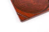 Close-up of the Blazy Susan Dab Tray corner, showcasing its reddish-brown birch wood with a carved circular recess, highlighting its organized, low-profile design.