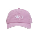 A light pink washed cotton rollers cap with the word slou embroidered in white across the front