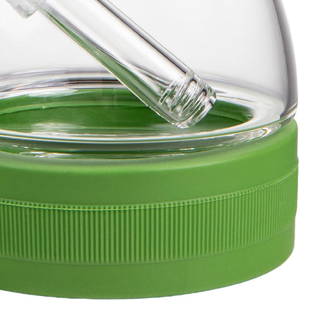 Close-up of a green lid with a clear glass container on a white background