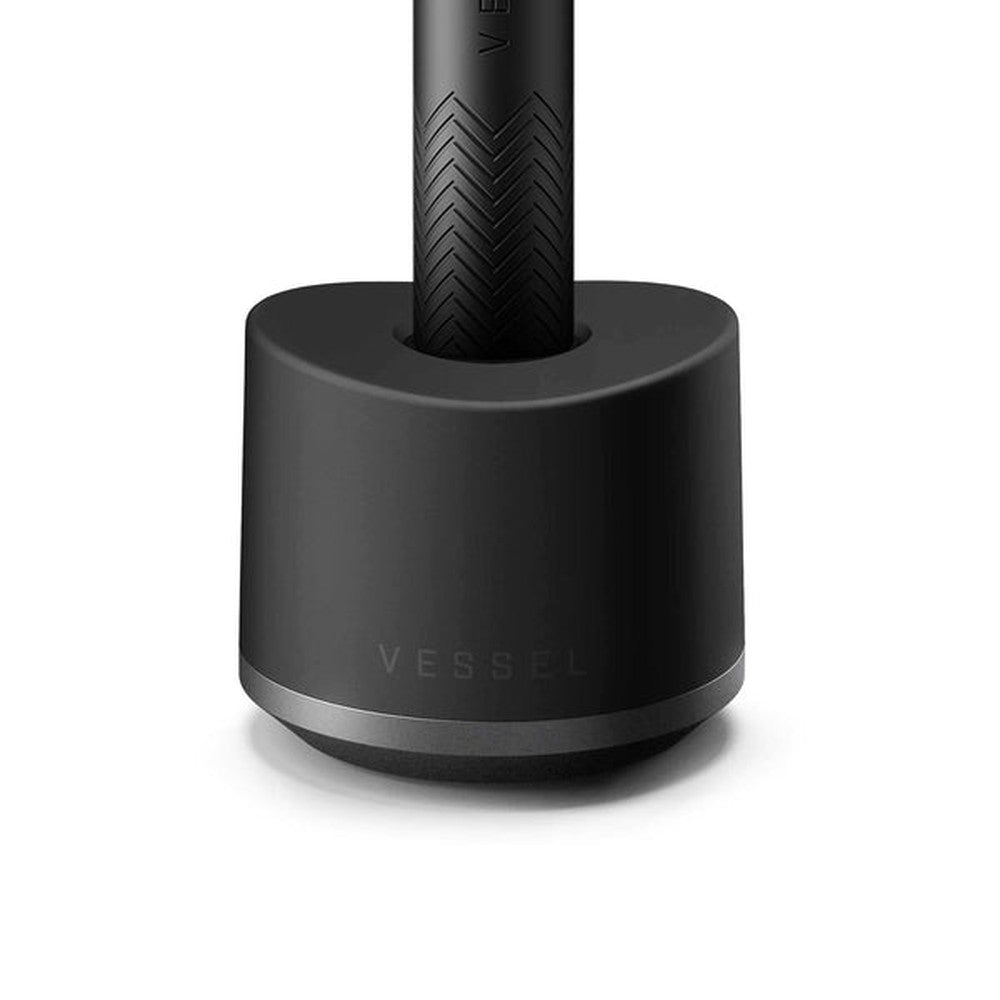Base Charger - Black: Matte-black cylindrical dock with VESSEL-embossed handle, designed for stable display and secure organization of compatible Vessel devices.