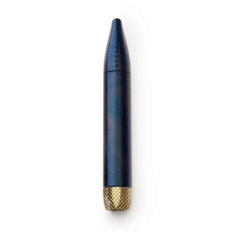 Helix Premium One Hitter, a blue topographic-patterned metal capsule with VESSEL branding and a knurled brass cap, designed for enhanced airflow and cooling.