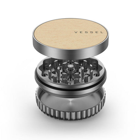 Vessel Mill Grinder, a 3-piece metal accessory with a wooden top, features a grinding section and catch-cup, ideal for precise herb preparation.