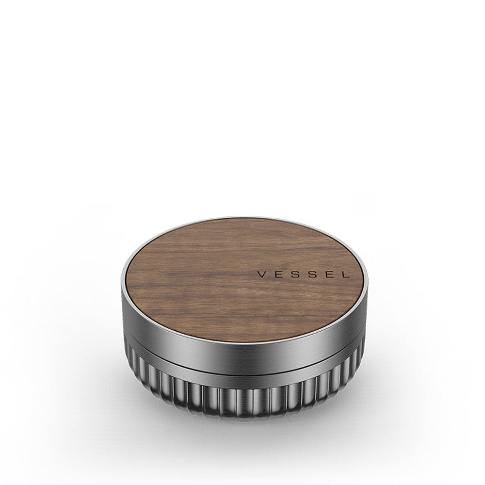 Vessel Mill Grinder with a walnut-wood top and fluted aluminum sides, featuring a smooth wooden lid stamped “VESSEL” for secure, precise herb grinding.