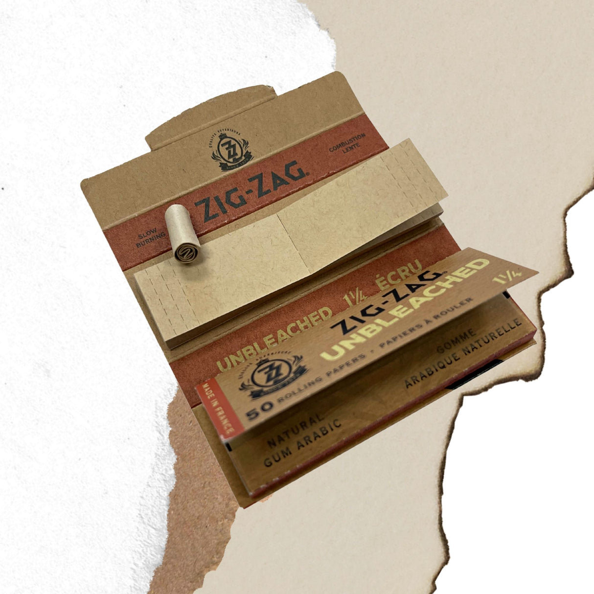 Unbleached 1 1/4 Papers & Tips box with visible logo and rolled cigarette on a white surface, showcasing natural gum Arabic and ultra-thin design.